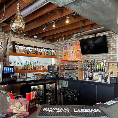 Bar area with exposed wooden ceiling beams, brick walls and well-stocked bar shelves.