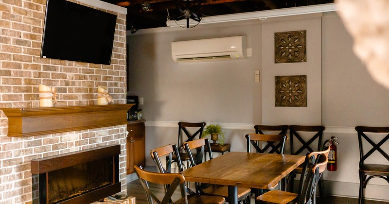 Interior, table and seats near a wall with fireplace and TV