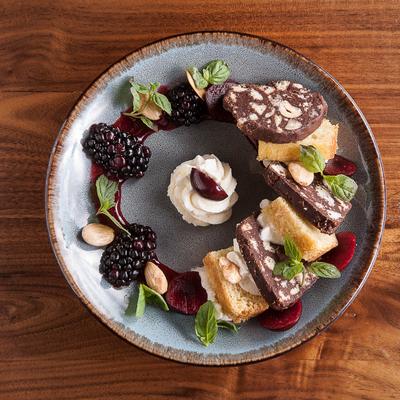 Chocolate salami, blackberries, cherries, whipped cream, and bread.