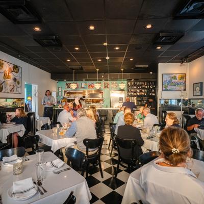 Busy restaurant dining room with people seated at tables.