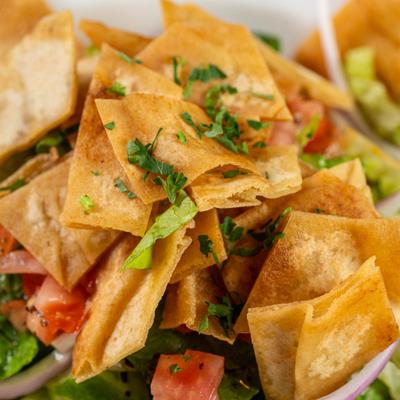 Close-up of crispy pita chips topped with herbs.