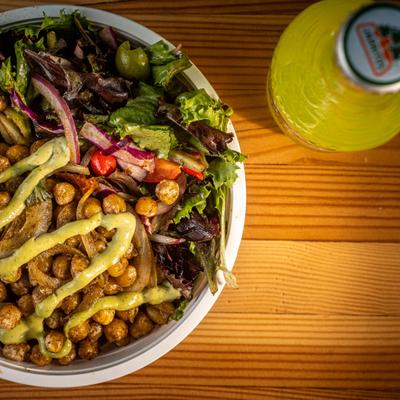 Chickpea bowl served alongside a bottle of soda, close-up.