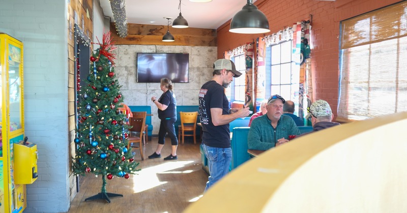 Interior, diner area, the waiter takes the order from the guest, booths and tables behind