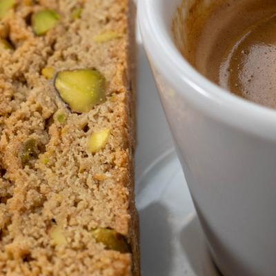Close up of pistachio biscotti with a cup of espresso.