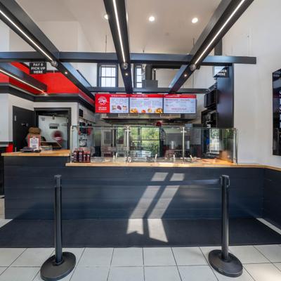 Interior counter area with exposed ceiling beams and digital menu boards.