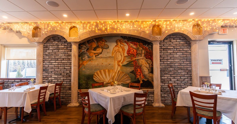 Interior, dining area, set tables with tableware and chairs, painting on the wall