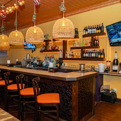 Well-stocked bar area with high chaors and drink shelves.