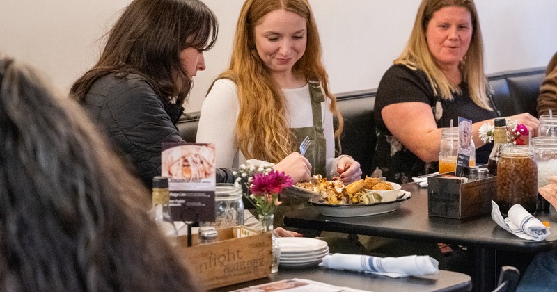 Diner table, food on, guests