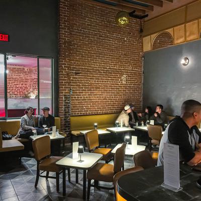 Interior, guests sitting at the bar and at tables.