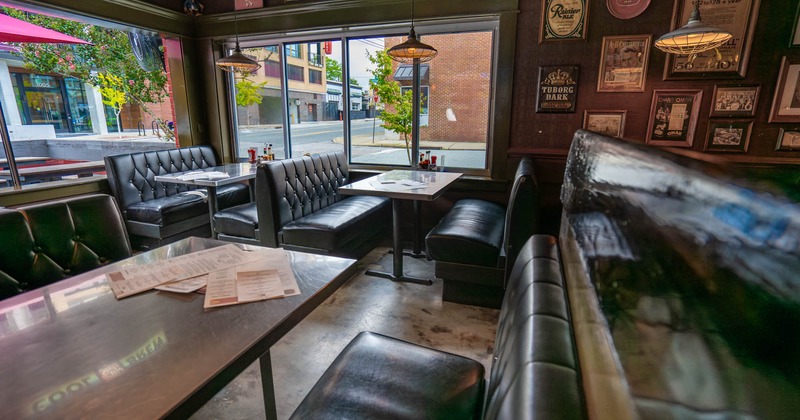 Interior with booths, tables, and vintage beer memorabilia on the walls