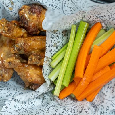 Glazed chicken wings with celery and carrots.