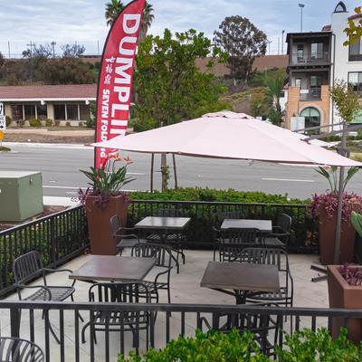 Restaurant's outdoor patio with tables, chairs and vertical banners.