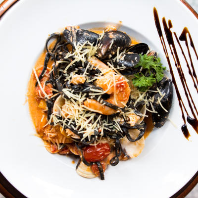 Black squid ink pasta topped with fresh shrimp, mussels, clams, and shredded cheese.