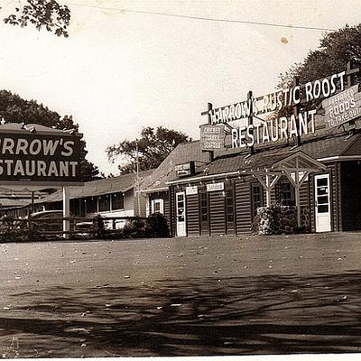 Retro picture of Harrow's Rustic Roost Restaurant with a large sign and a rustic wooden building.