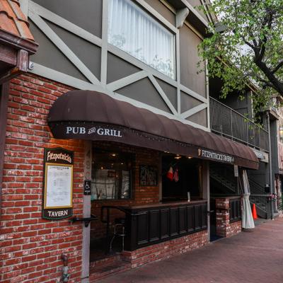 Restaurant entrance with brown awning and brick wall.