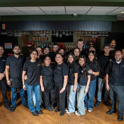 Group of the restaurant staff standing together inside.