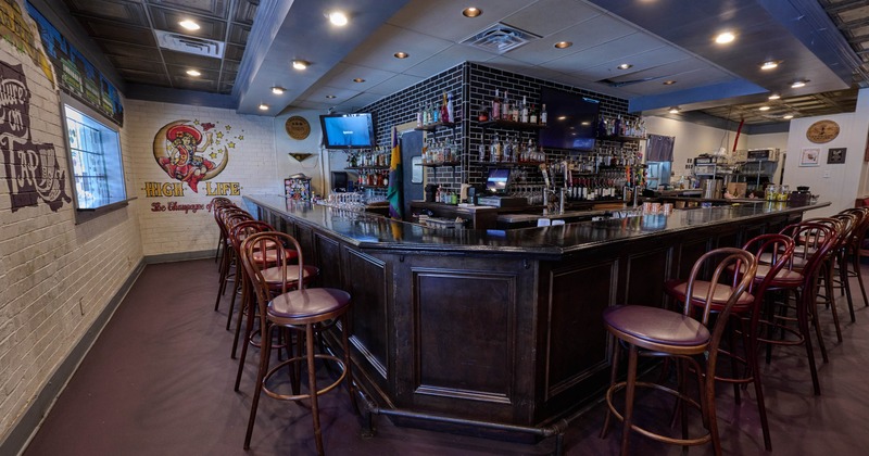 Interior seating area with a dark wooden counter and barstools