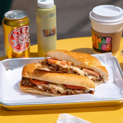 Pulled pork sandwich, with tomato, onions, and garlic sauce.