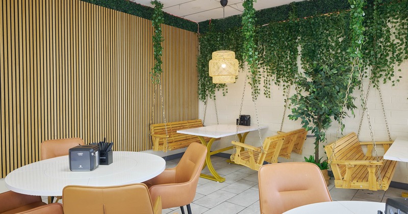 Interior, dining area, corner seating, tables with swing style benches, plant decoration