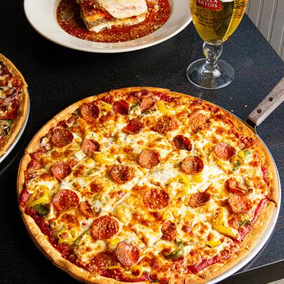 Pizza with extra sausage, glass of beer on the side