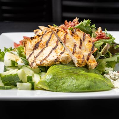 Cobb salad topped with grilled chicken breast.