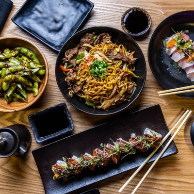 Assorted Japanese dishes including edamame, sushi rolls, and noodles.