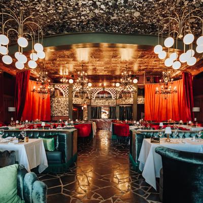 The whole dining area, tables set, curtains, chandeliers.