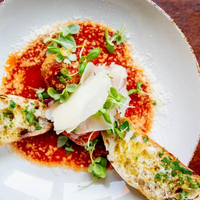 Mini Meatballs in marinara sauce, served with  shaved Parmesan cheese, and crostini