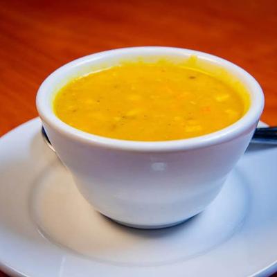 Bowl of lentil soup on a white plate.