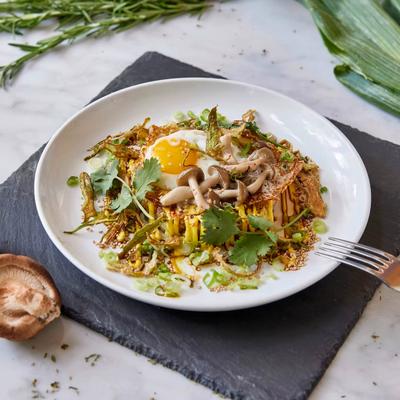 Crispy rice cake topped with a fried egg, mushrooms, herbs and scallions.
