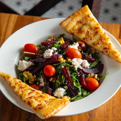 Arugula and Beet Salad topped with cherry tomatoes, walnuts and feta, served with cheesy bread.