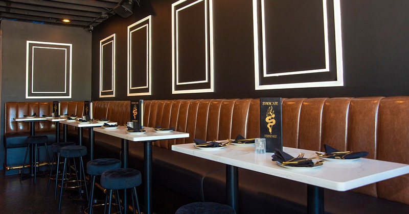 Restaurant interior, lined up dining tables set for guests