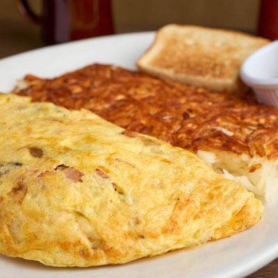 Ham and cheese omelet served with hash browns and toast.