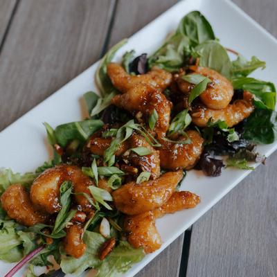 Sticky shrimp served over a bed of greens.