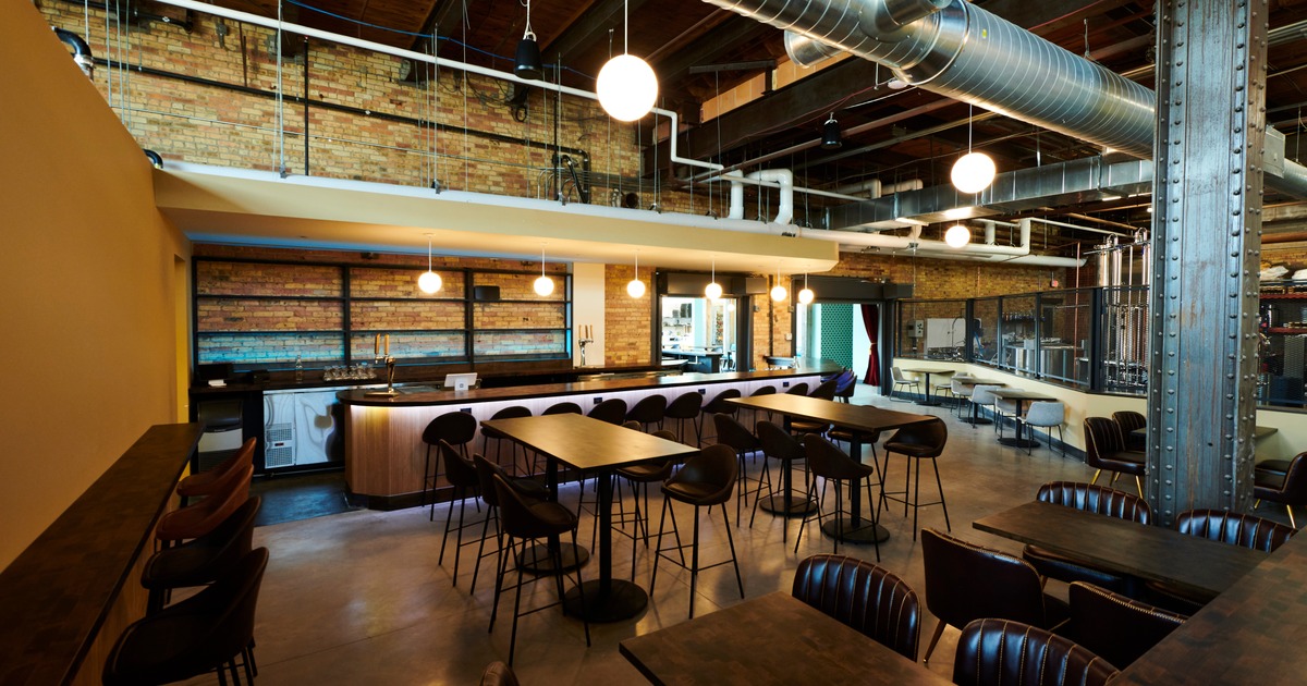 Industrial bar interior with tables and modern lighting