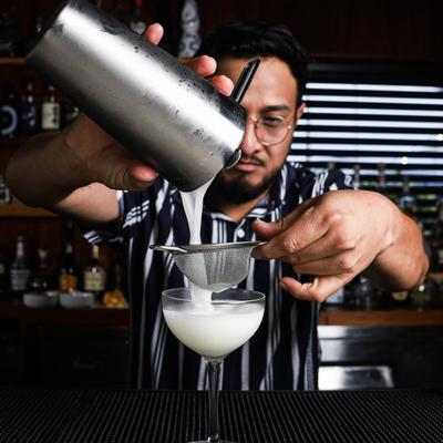 A person preparing a cocktail.