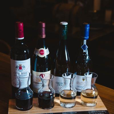 Wine flight with wine bottles behind it.