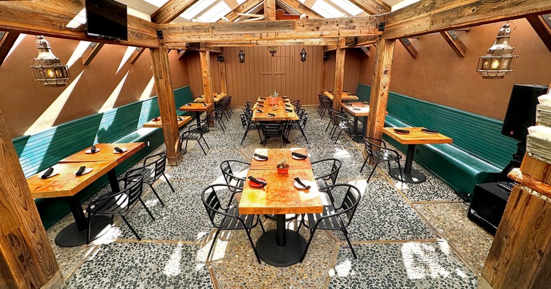 Dining area featuring wooden beams, high ceilings with skylights, wooden tables and seating