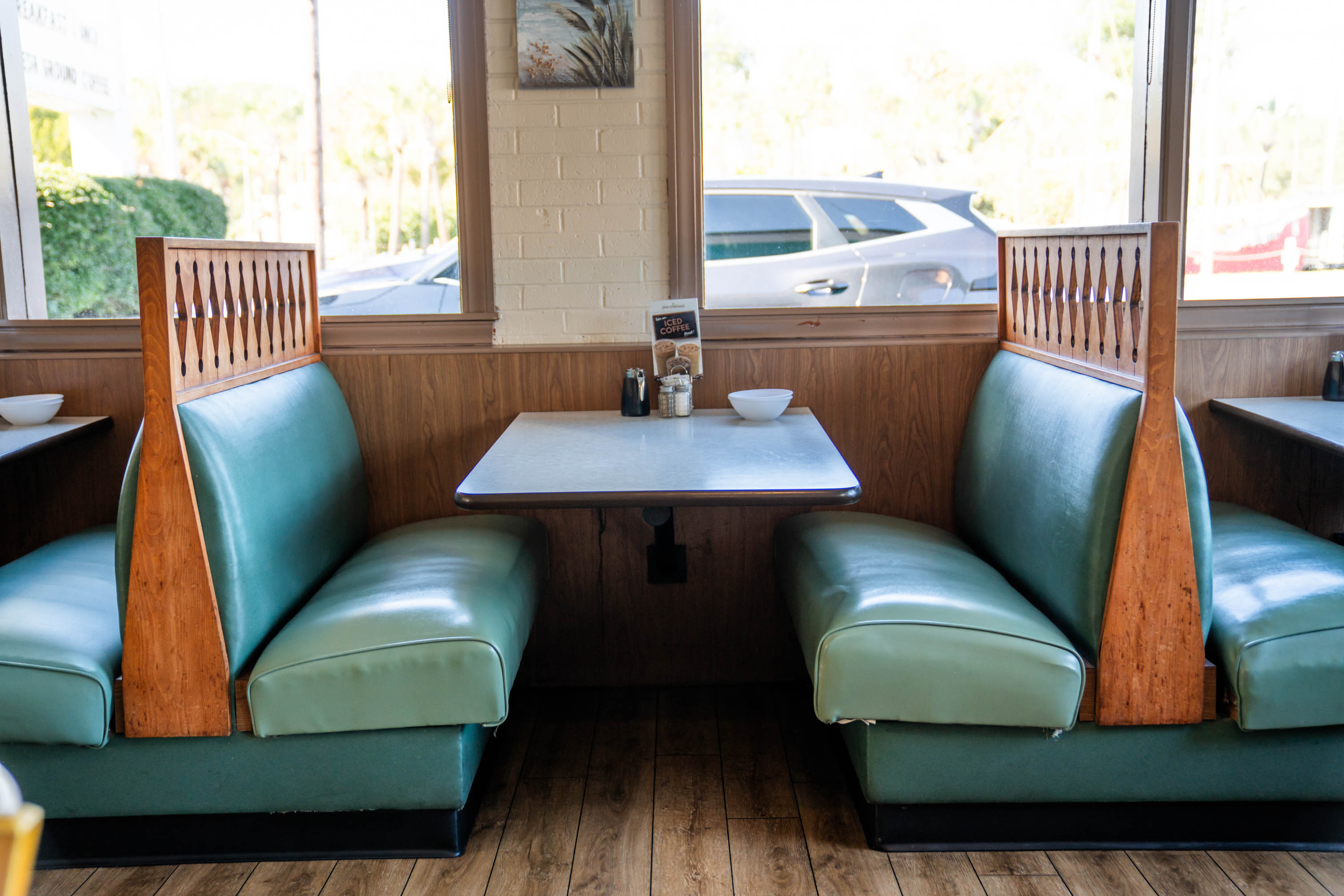 View at the booth with table set with salt and pepper shakers and a small bowl