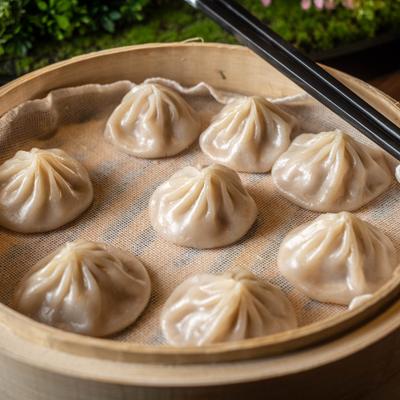 Steamed dumplings arranged in a bamboo steamer basket.