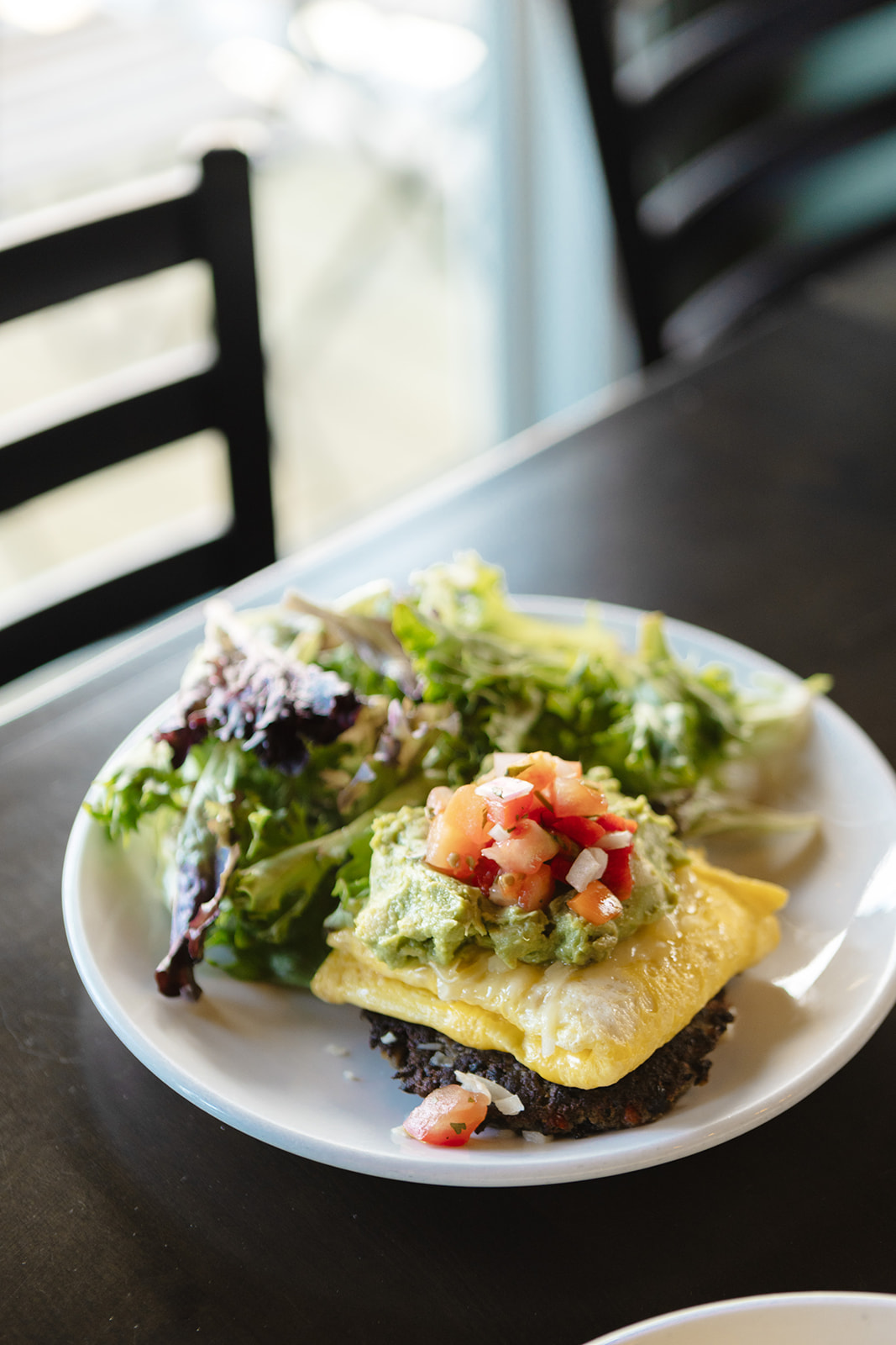 black bean fritter with scrambled eggs, pico, and avocado overlooking the deck.