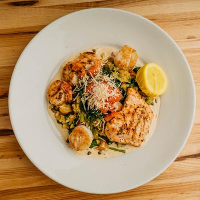 Wood fired salmon, scallops, and shrimp, with veggie risotto, and lemon caper sauce.