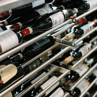 Assorted wine bottles stored horizontally on metal racks.