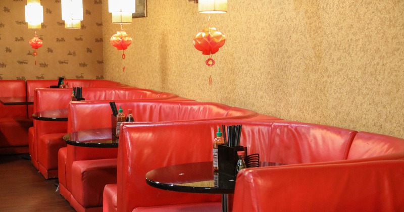 Restaurant interior with red leather booths, pendant lights, and red lanterns
