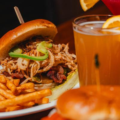 Parmesan Shoestring Onion Burger served with fries alongside a drink.