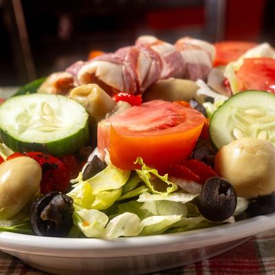 Antipasto Salad, with lettuce, tomato, mushrooms, peppers, olives, salami, capicola, and provolone.
