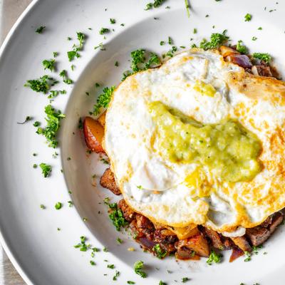 Short rib hash topped with fried eggs and guacamole.