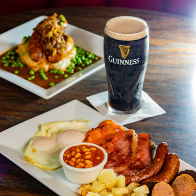 Full English breakfast, a glass of Guinness and peas and sausages dish