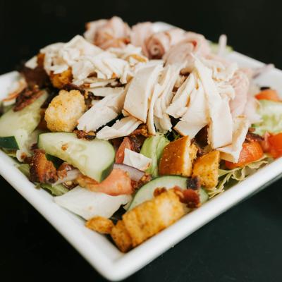 Salad, topped with shredded chicken & ham, diced tomatoes, cucumbers & croutons.