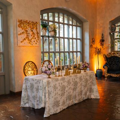 Banquet hall with a sweetheart table with floral centerpiece and decorations.